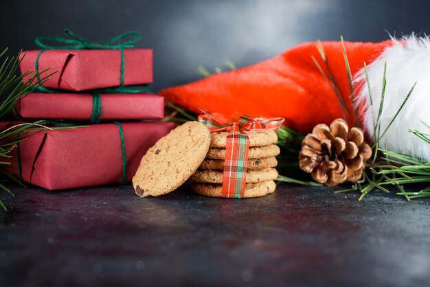 Délicieux biscuits sablés aux morceaux de chocolat, avec ruban rouge, un brin d'épinette, Bonnet du Père Noël, un shortie. Composition de Noël