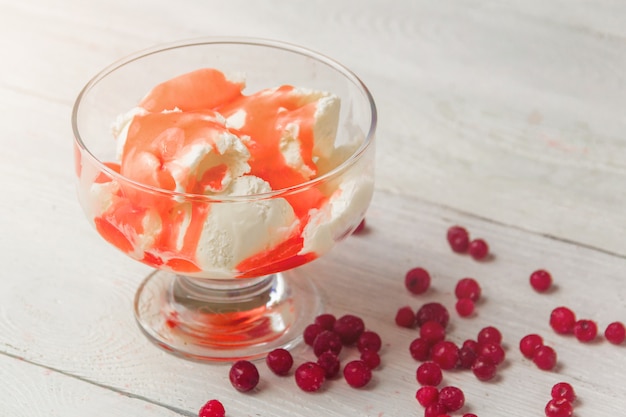 Délicieux bol de glace vanille avec garniture à la fraise et aux canneberges