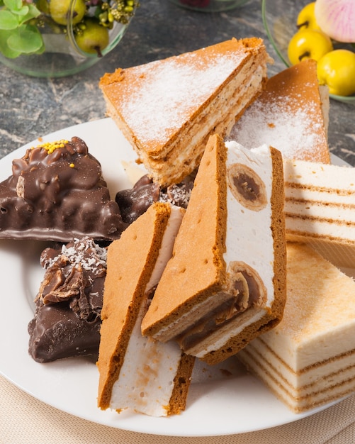 Délicieux bonbons assortis sur une assiette: gâteaux soufflés et brownies au chocolat et aux noix