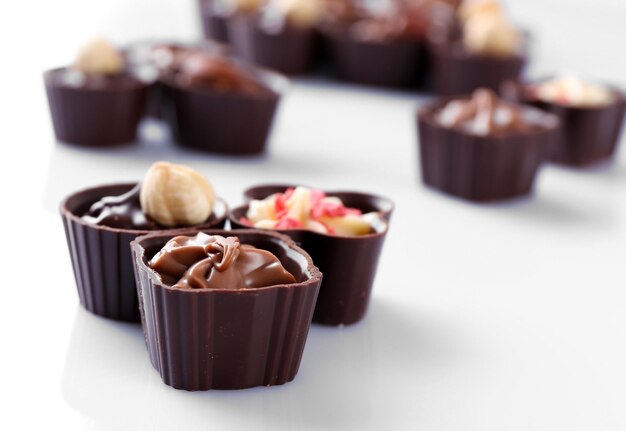 Délicieux bonbons au chocolat sur fond blanc, gros plan