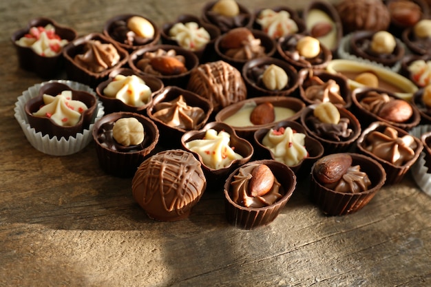 Délicieux bonbons au chocolat sur table en bois, gros plan