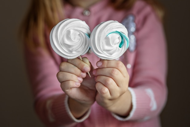 Délicieux bonbons sur un bâton dans les mains des enfants. Le concept de bonbons, fête, boulangerie.