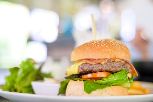 Délicieux burger au boeuf servi sur une assiette avec des sauces et de la laitue