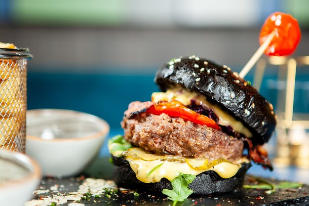 Délicieux burger de bœuf noir savoureux avec frites et soia sos