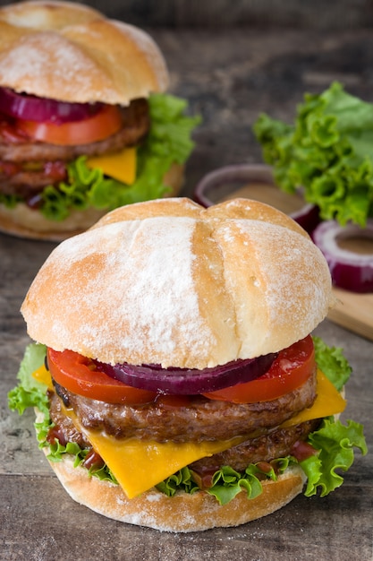 Délicieux burger de boeuf servi sur une plaque en bois. Style traditionnel