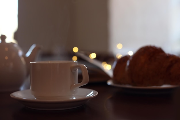 Délicieux café et croissant du matin servis pour le petit-déjeuner sur une table en bois