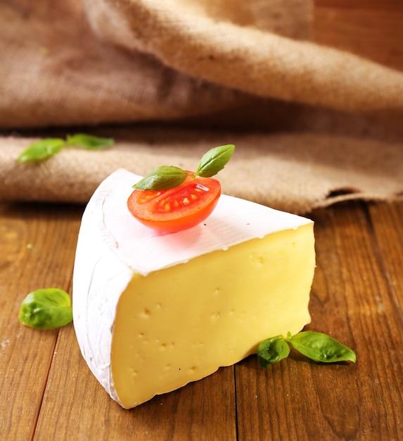 Délicieux camembert à la tomate et au basilic sur une table en bois