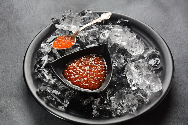 Délicieux caviar rouge avec des glaçons sur une assiette