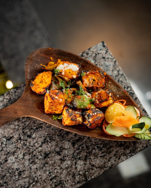 un délicieux et chaud paneer tikka avec de la sauce sur fond de bois