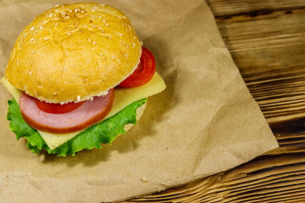 Délicieux cheeseburger maison frais sur papier brun sur table en bois