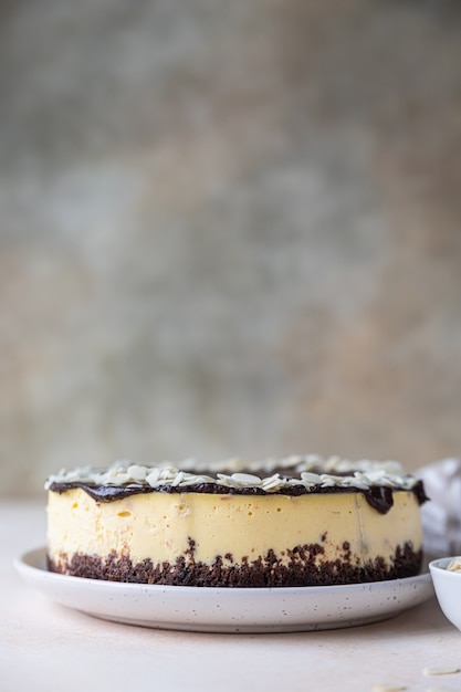 Délicieux cheesecake crémeux décoré de glaçage au chocolat et d'amandes Dessert mousse sans cuisson