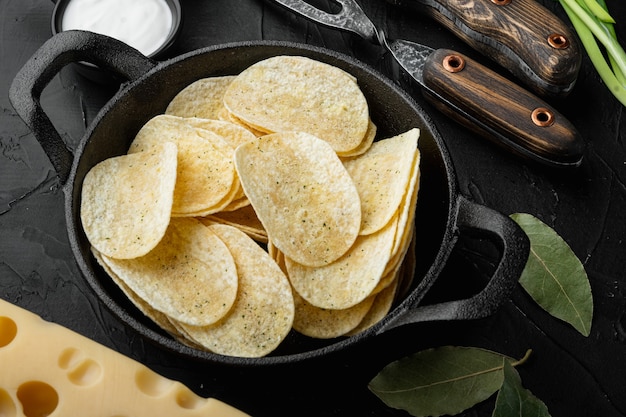 Délicieux chips de pommes de terre croustillantes, sur table en pierre noire