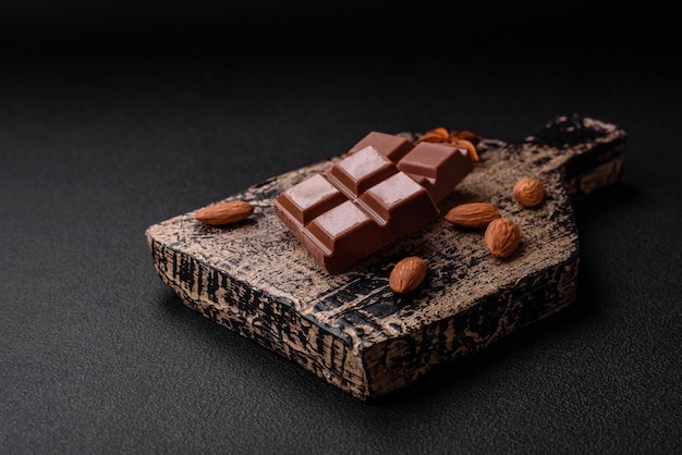 Délicieux chocolat au lait sucré cassé en cubes sur une planche à découper en bois