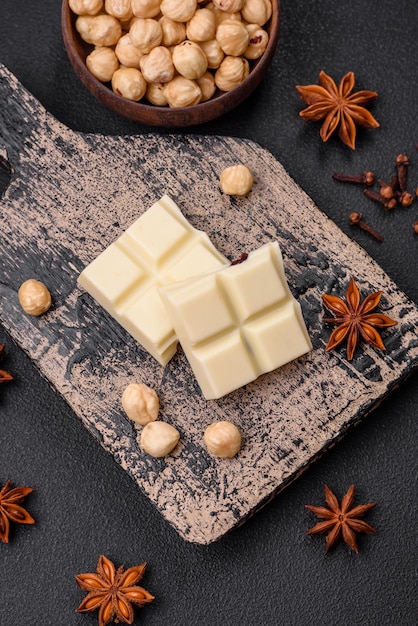 Délicieux chocolat blanc sucré cassé en cubes sur une planche à découper en bois