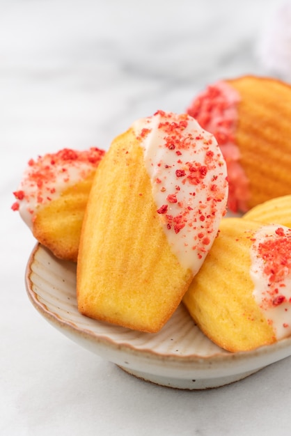 Délicieux chocolat maison trempé madeleine avec des morceaux de fruits secs sur tableau blanc