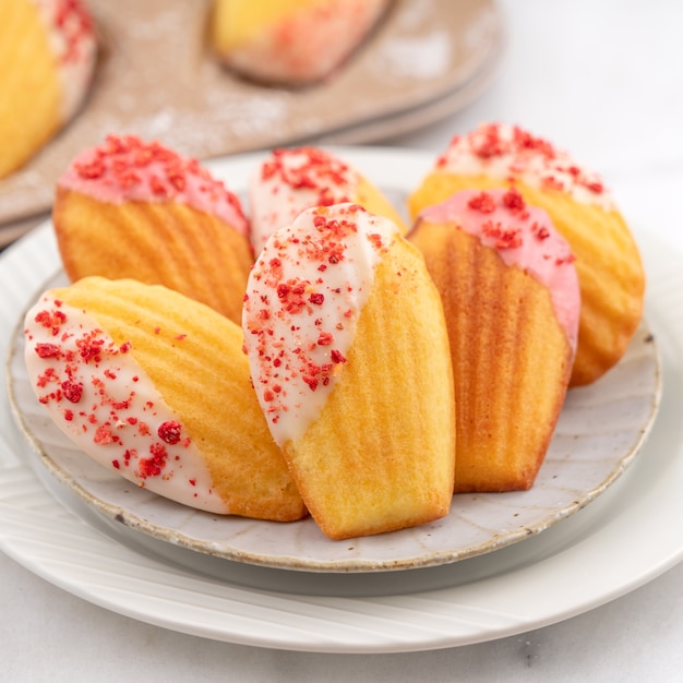 Délicieux chocolat maison trempé madeleine avec des morceaux de fruits secs sur tableau blanc