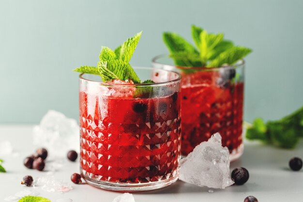 Délicieux cocktail de boisson fraîchement préparé avec de la mûre et de la menthe. Servi dans des verres. Fermer