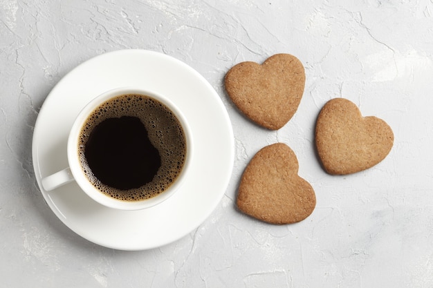 De délicieux coeurs de biscuits faits maison avec une tasse de café sur fond clair. Vue de dessus. Place pour le texte.