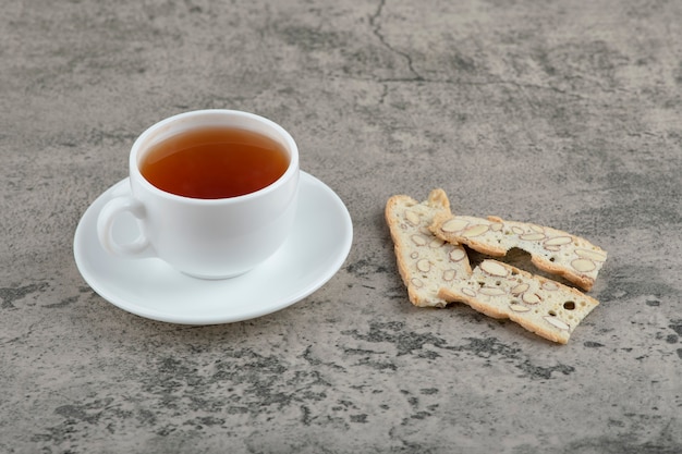 Délicieux craquelins aux noix et tasse de thé chaud sur pierre.