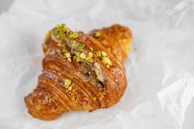 Un délicieux croissant aux pistaches sur papier sulfurisé