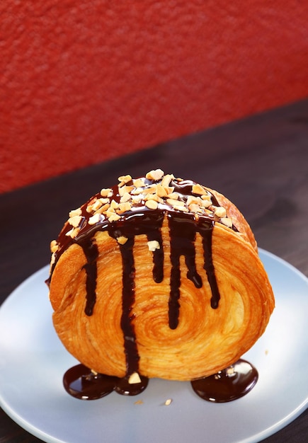 Un délicieux croissant circulaire avec du ganache au chocolat et des noix hachées