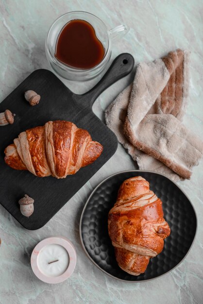 Délicieux croissant croustillant au chocolat avec une tasse de café revigorant sur un fond de béton léger Délicieux petit-déjeuner nutritif