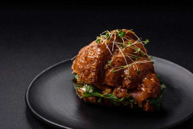 Délicieux croissant croustillant avec du fromage de laitue saumonée et des tomates