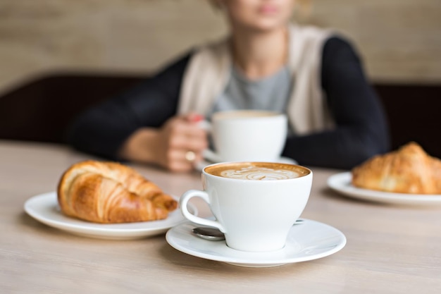 Délicieux croissant avec du café dans une tasse blanche