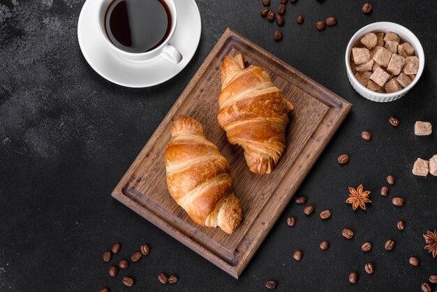 Délicieux croissant français croustillant frais avec une tasse de café parfumé. Petit-déjeuner revigorant