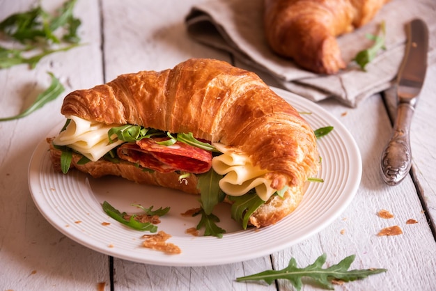 Photo délicieux croissant sandwich au fromage et à la roquette