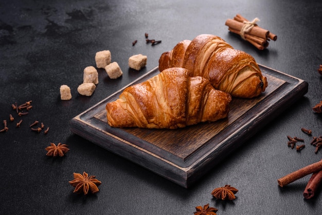 Délicieux croissants frais et croustillants sur fond de béton foncé. Petit déjeuner savoureux