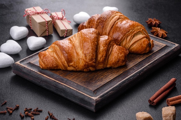 Délicieux croissants frais et croustillants sur fond de béton foncé. Petit déjeuner savoureux