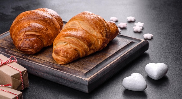 Délicieux croissants frais et croustillants sur fond de béton foncé. Petit déjeuner savoureux