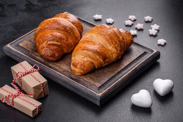 Délicieux croissants frais et croustillants sur fond de béton foncé. Petit déjeuner savoureux