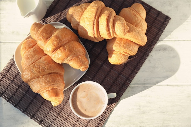 De délicieux croissants avec une tasse de café sur la table