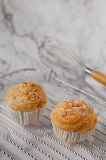 De délicieux cruffins modernes sont fabriqués à partir de croissants en couches en forme de muffin en forme de cupcake. garniture aux amandes.