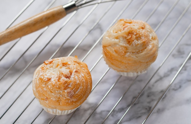 De délicieux cruffins modernes sont fabriqués à partir de croissants en couches en forme de muffin en forme de cupcake. garniture aux amandes.