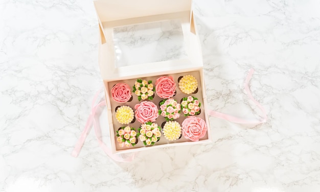 Délicieux cupcakes gourmands garnis de fleurs glacées à la crème au beurre