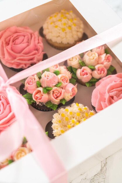 De délicieux cupcakes gourmets surmontés de fleurs au glaçage au beurre de crème