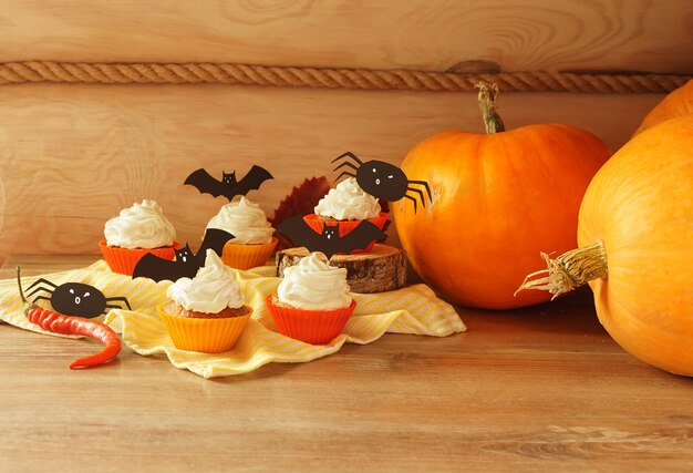 Délicieux cupcakes d'Halloween sertis de décorations lumineuses. Bonbons d'Halloween, confiseries maison, nourriture de vacances, concept de friandises ou de friandises