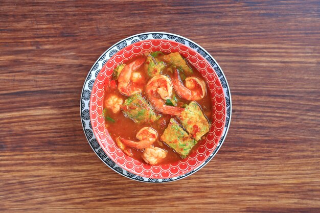 Délicieux curry jaune thaïlandais avec crevettes et omelette de légumes aux herbes frites dans un bol