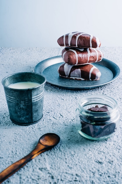 Délicieux dessert fait maison de chocolat noir et blanc fourré de crème. Dessert en forme de triangle sur table en bois