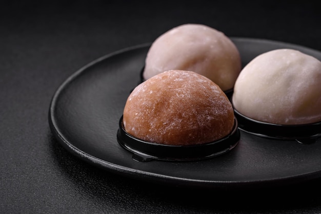 Délicieux dessert mochi sucré avec garnitures sur fond de béton foncé