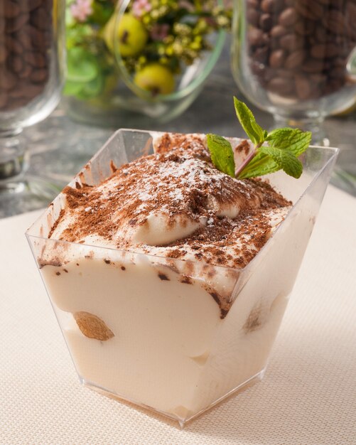 Délicieux dessert tiramisu dans un récipient rectangulaire décoré de menthe