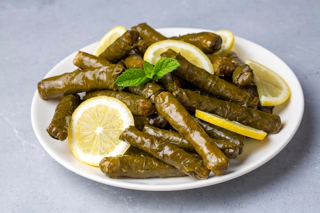 Délicieux dolma (sarma) riz aux feuilles de vigne farcies, sauce yaourt blanc. Dolma sarma libanais sur assiette. Liban turc grec cuisine moyen-orientale. (nom turc; Yaprak sarma)