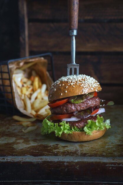 Délicieux double burger avec frites sur fond sombre, restaurant atmosphérique, photographie culinaire