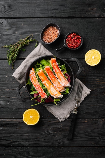 Délicieux ensemble de grappes de pattes de crabe des neiges, sur fond de table en bois noir, vue de dessus à plat, avec espace de copie pour le texte