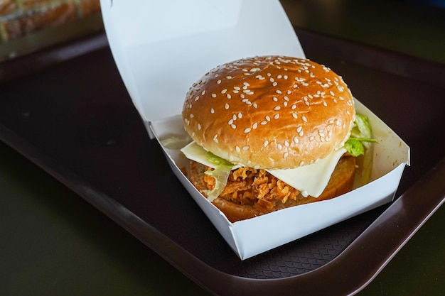 Délicieux fast-food Juicy cheeseburger dans une boîte d'alimentation en papier blanc