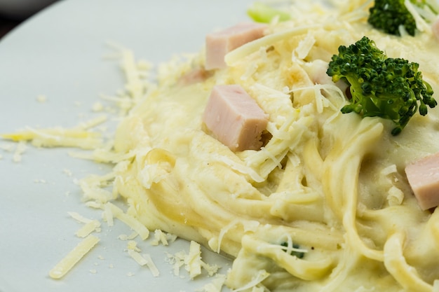 Délicieux Fettuccine avec sauce blanche, brocoli, cubes de poitrine de dinde et fromage râpé. Mise au point sélective.