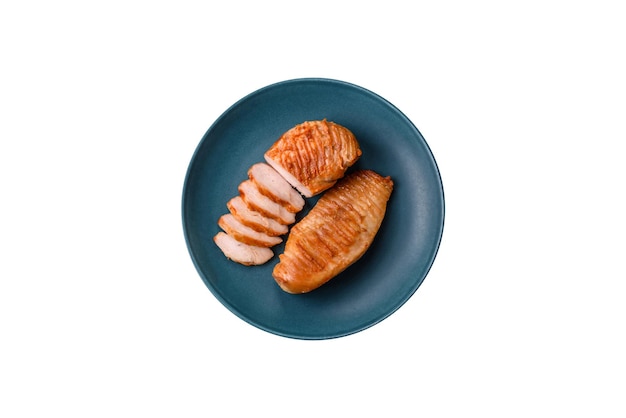 Délicieux filet de poulet frais grillé avec des épices et des herbes sur un fond de béton sombre